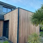 Extension ossature bois, toit plat avec membrane type EPDM. Pose de bardage red cedar claire voie couleur naturelle en position verticale